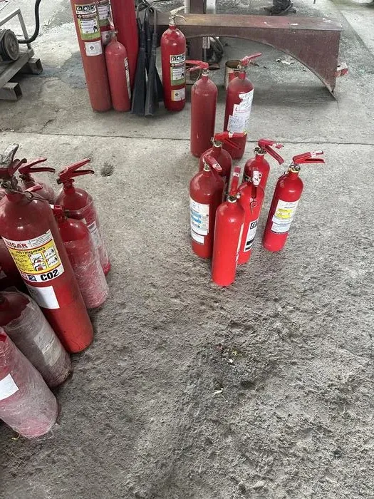 Técnico cargando extintores CO₂ en taller PREVIFUEGO